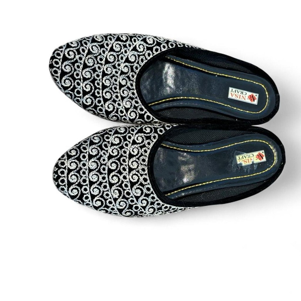 Black and white leather slip on shoes with embroidered pattern. Size 7